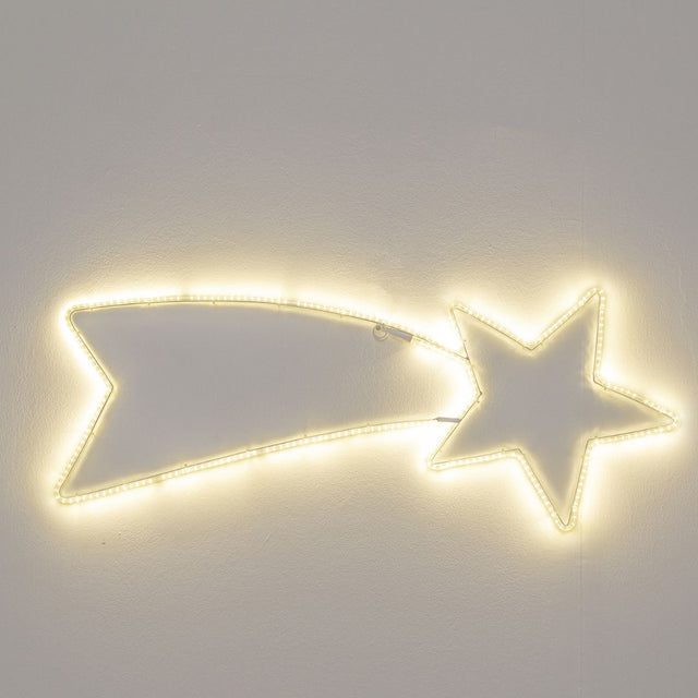 Decorazione natalizia a forma di stella cometa illuminata con luce LED bianco caldo, accesa su sfondo grigio.