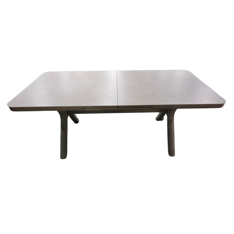 Tavolo da esterno allungabile con piano in pietra grigia e struttura in alluminio color crema.