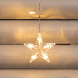 Dettaglio della stella della tenda luminosa con stelle bianco caldo su saracinesca esterna.