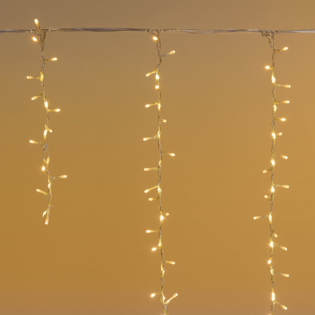 Tenda cluster con LED bianco caldo e fili che scendono di diverse lunghezze.
