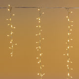 Tenda cluster con LED bianco caldo e fili che scendono di diverse lunghezze.