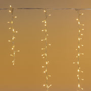 Tenda cluster con LED bianco caldo e fili che scendono di diverse lunghezze.