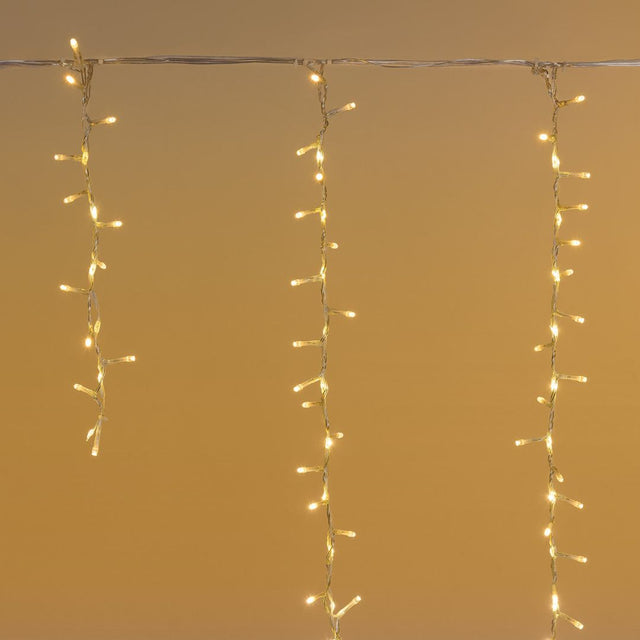 Tenda cluster con LED bianco caldo e fili che scendono di diverse lunghezze.