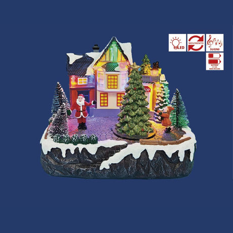 Villaggio natalizio in miniatura con casa illuminata, albero decorato, Babbo Natale e una bambina tra alberi innevati su sfondo blu.