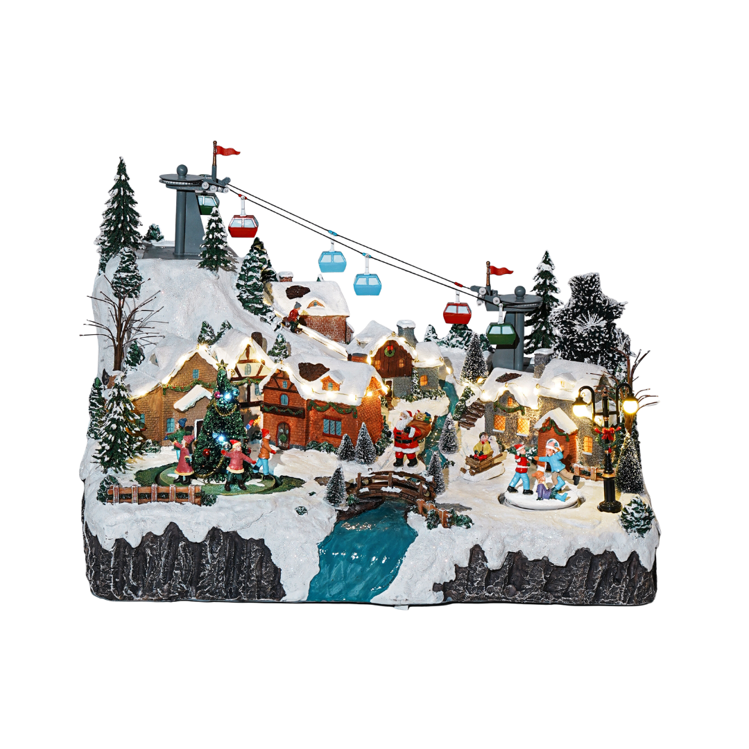 Villaggio natalizio innevato di montagna con case illuminate, funivia, personaggi attorno all’albero di Natale, Babbo Natale, ponte e ruscello