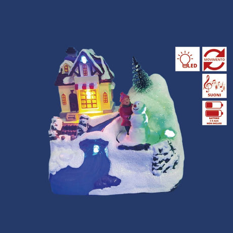 Villaggio natalizio con casa illuminata, bambina accanto a un pupazzo di neve e decorazioni innevate con luci LED colorate su sfondo blu.