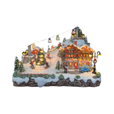 Villaggio natalizio innevato con Ski Hotel illuminato, funivia sospesa, sciatori attorno all’albero di Natale, automobile, abeti e lampioni