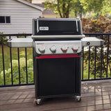 Barbecue a gas Weber Spirit EP-425 posizionato su terrazza esterna con ringhiera e giardino sullo sfondo.