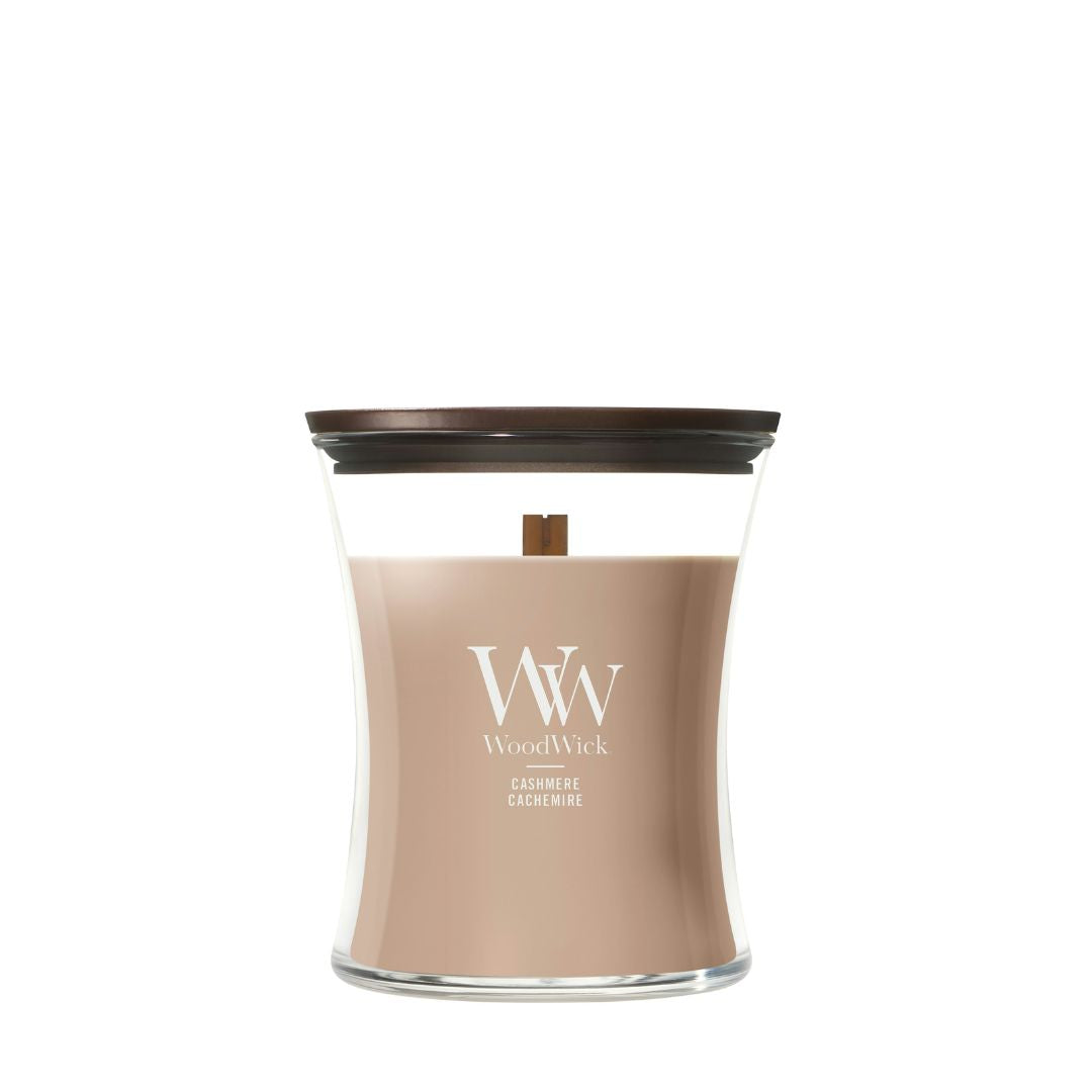 Candela WoodWick Cashmere media in vaso di vetro con coperchio in legno.