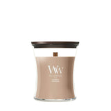 Candela WoodWick Cashmere media in vaso di vetro con coperchio in legno.