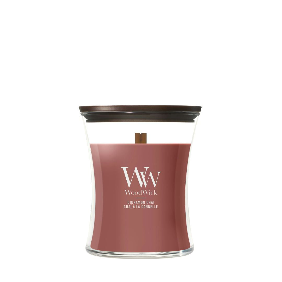 Candela WoodWick Cinnamon Chai media in vaso di vetro con coperchio in legno.