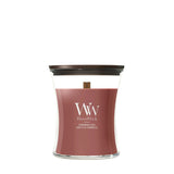 Candela WoodWick Cinnamon Chai media in vaso di vetro con coperchio in legno.