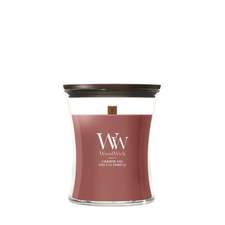Candela WoodWick Cinnamon Chai media in vaso di vetro con coperchio in legno.