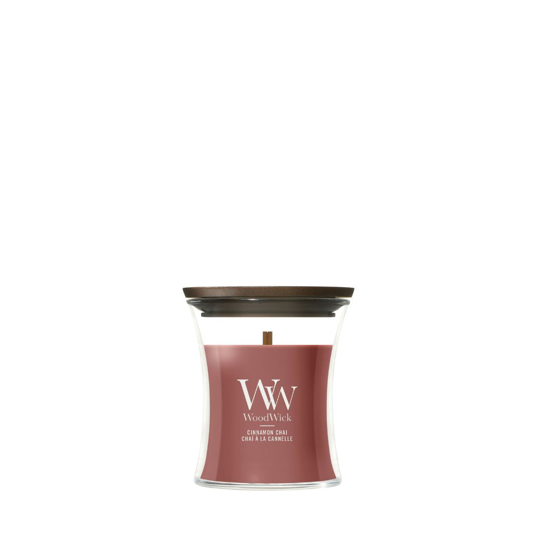 Candela WoodWick Cinnamon Chai piccola in vaso di vetro con coperchio in legno.