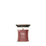 Candela WoodWick Cinnamon Chai piccola in vaso di vetro con coperchio in legno.