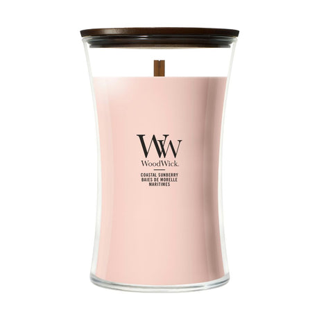 Candela WoodWick Coastal Sunberry grande in vaso di vetro con coperchio in legno.