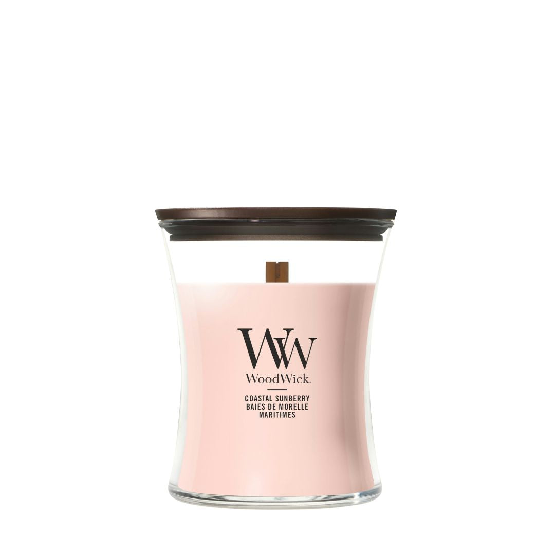 Candela WoodWick Coastal Sunberry media in vaso di vetro con coperchio in legno.