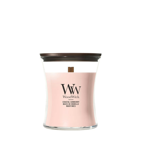Candela WoodWick Coastal Sunberry media in vaso di vetro con coperchio in legno.