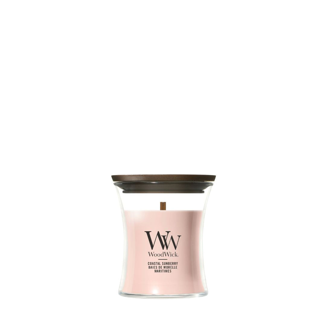 Candela WoodWick Coastal Sunberry piccola in vaso di vetro con coperchio in legno.