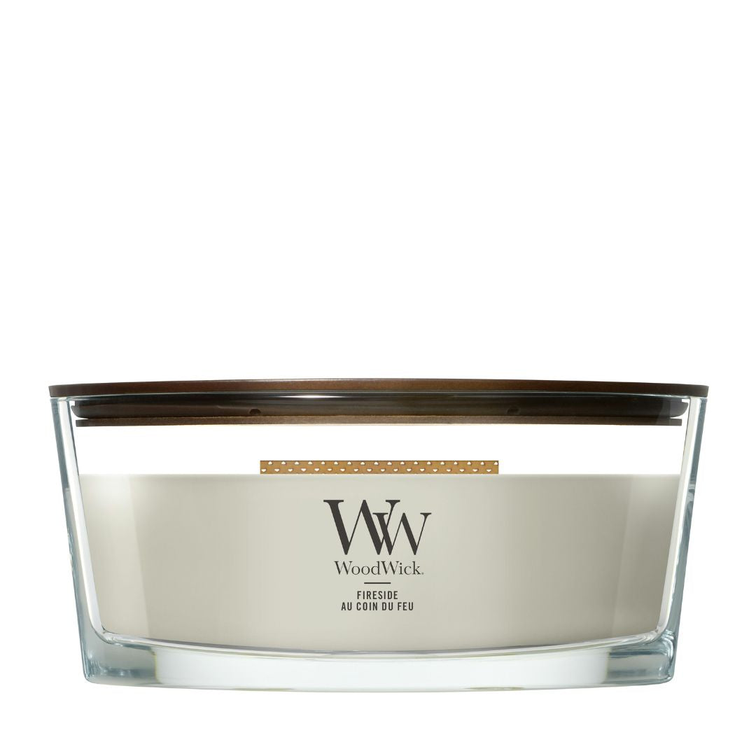 Candela WoodWick Fireside Ellipse in vaso di vetro con coperchio in legno.
