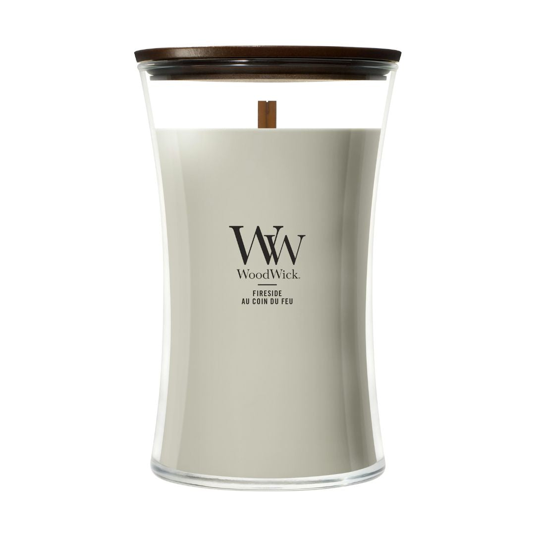 Candela WoodWick Fireside grande in vaso di vetro con coperchio in legno.