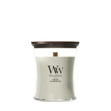 Candela WoodWick Fireside media in vaso di vetro con coperchio in legno.