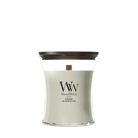 Candela WoodWick Fireside media in vaso di vetro con coperchio in legno.