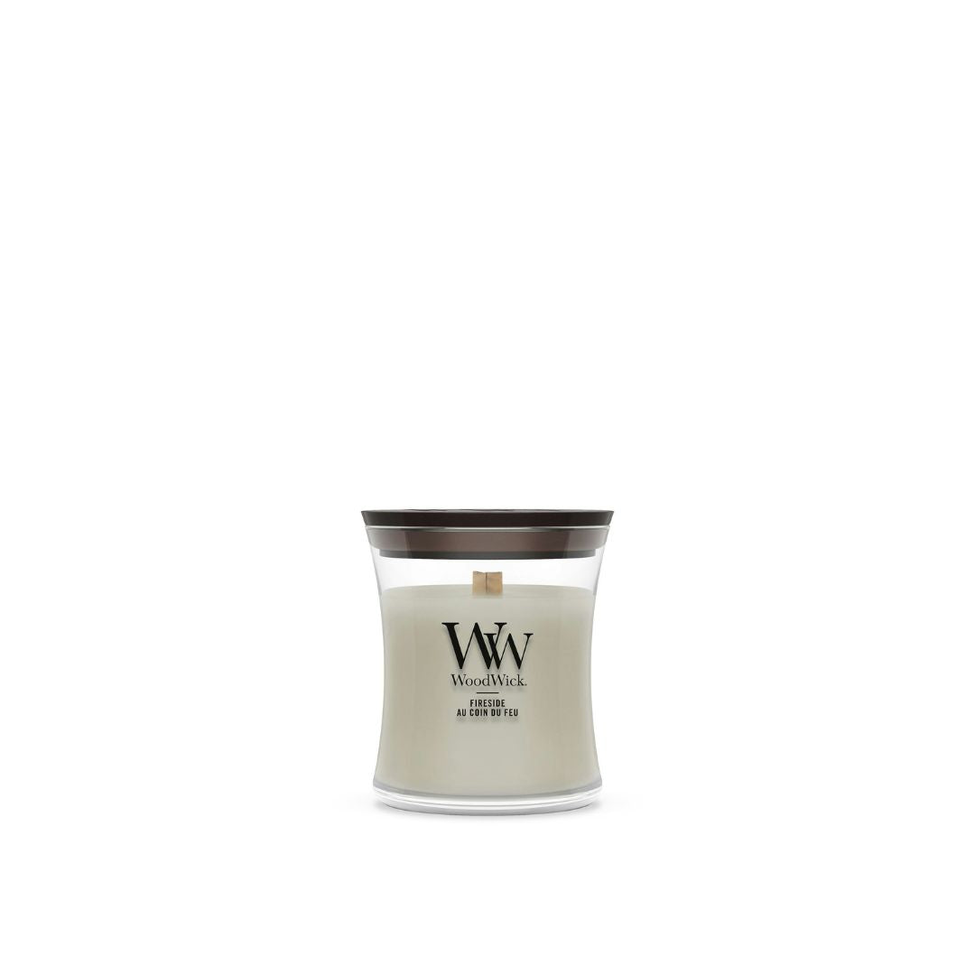 Candela WoodWick Fireside piccola in vaso di vetro con coperchio in legno.