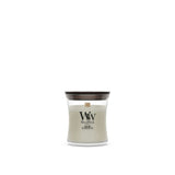 Candela WoodWick Fireside piccola in vaso di vetro con coperchio in legno.