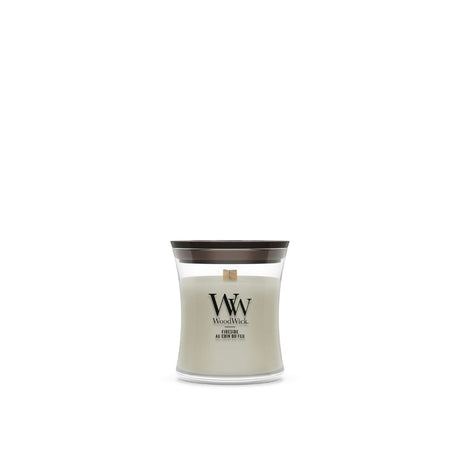 Candela WoodWick Fireside piccola in vaso di vetro con coperchio in legno.