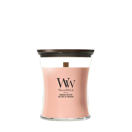 Candela WoodWick Manuka Nectar media in vaso di vetro con coperchio in legno.