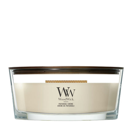 Candela WoodWick Patchouli Crème Ellipse in vaso di vetro con coperchio in legno.
