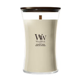 Candela WoodWick Patchouli Crème grande in vaso di vetro con coperchio in legno.