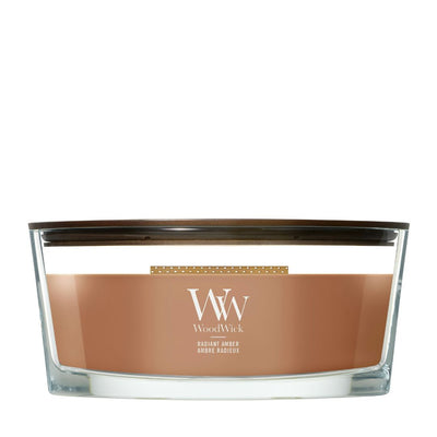 Candela WoodWick Radiant Amber Ellipse in vaso di vetro con coperchio in legno.