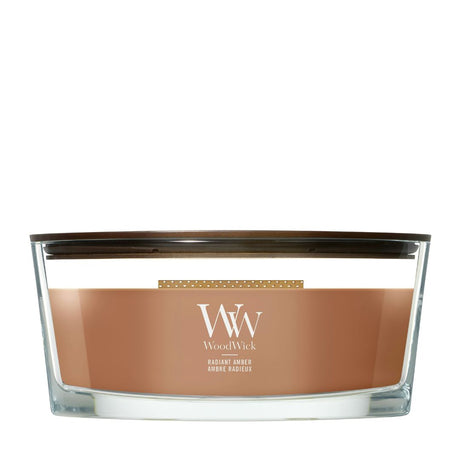 Candela WoodWick Radiant Amber Ellipse in vaso di vetro con coperchio in legno.