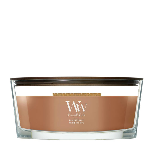 Candela WoodWick Radiant Amber Ellipse in vaso di vetro con coperchio in legno.