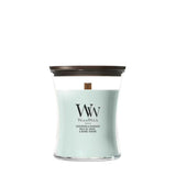 Candela WoodWick Sagewood & Seagrass media in vaso di vetro con coperchio in legno.
