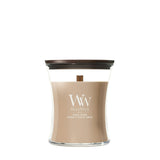 Candela WoodWick Santal Myrrh media in vaso di vetro con coperchio in legno.