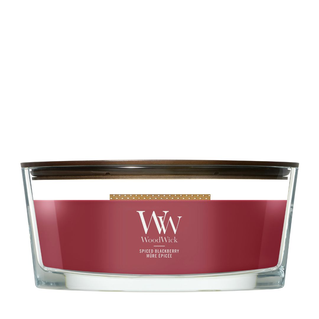 Candela WoodWick Spiced Blackberry Ellipse in vaso di vetro con coperchio in legno.