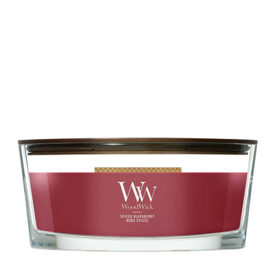 Candela WoodWick Spiced Blackberry Ellipse in vaso di vetro con coperchio in legno.