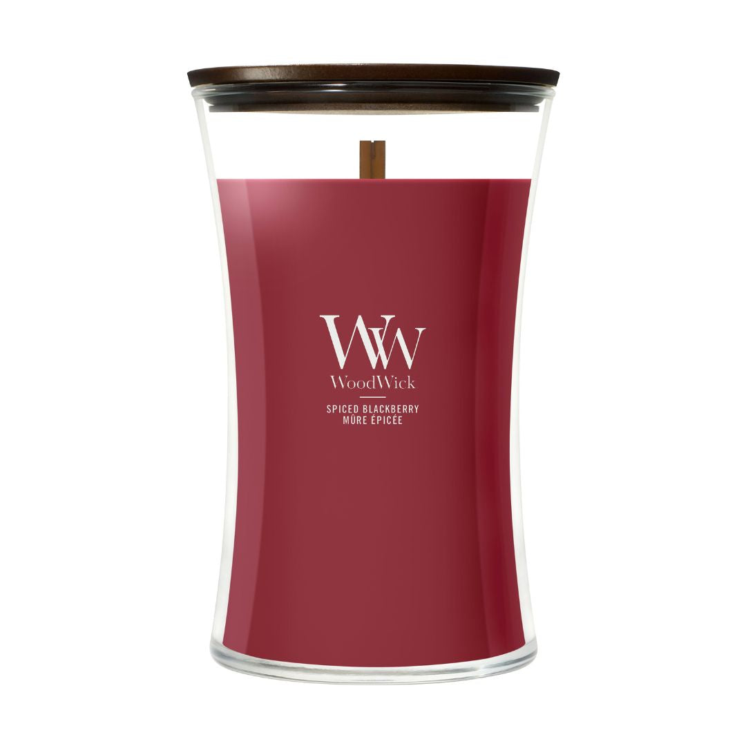 Candela WoodWick Spiced Blackberry grande in vaso di vetro con coperchio in legno.