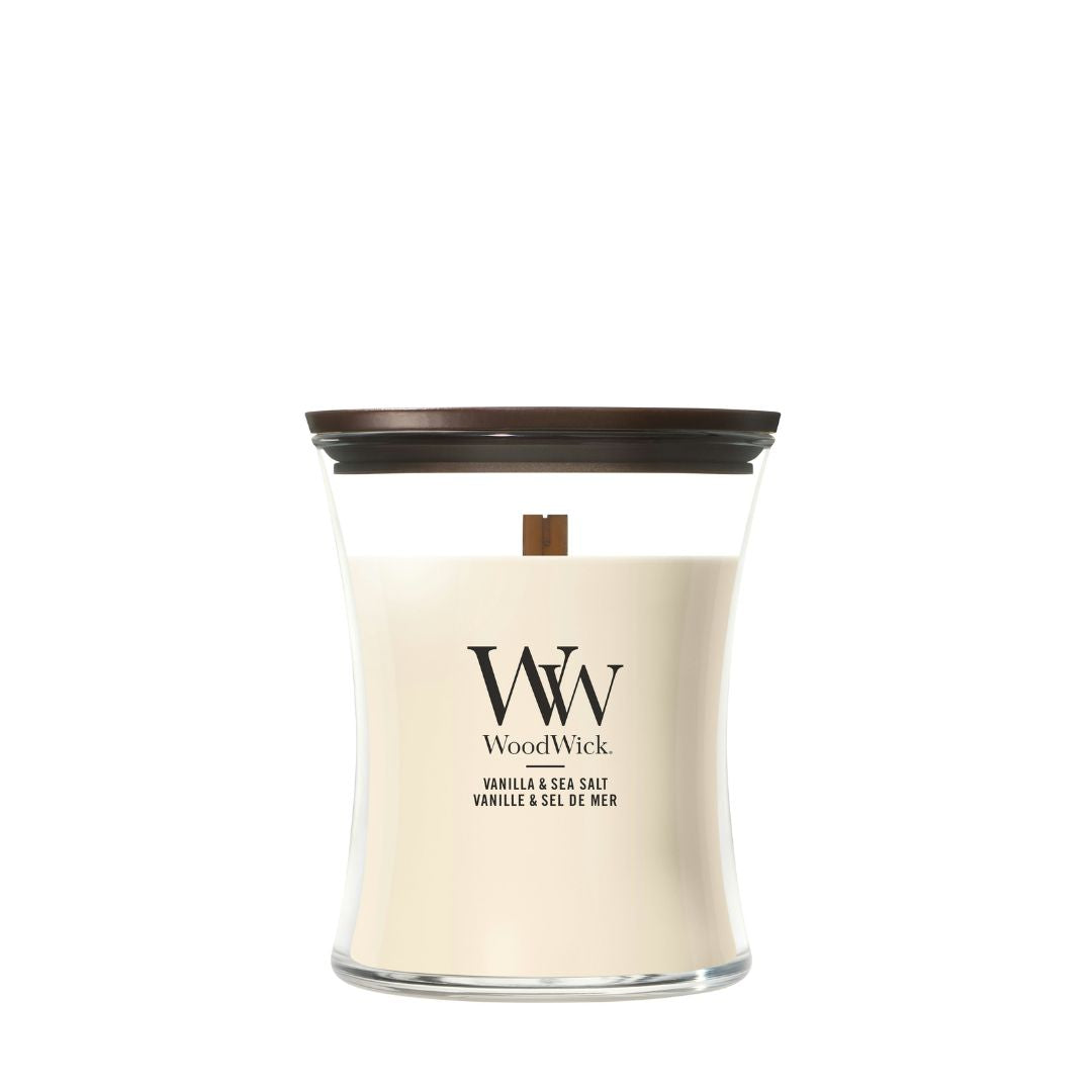Candela WoodWick Vanilla & Sea Salt media in vaso di vetro con coperchio in legno.
