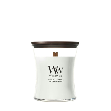 Candela WoodWick White Tea & Jasmine media in vaso di vetro con coperchio in legno.