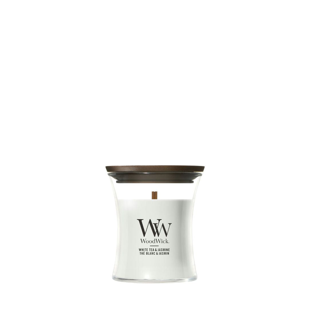 Candela WoodWick White Tea & Jasmine piccola in vaso di vetro con coperchio in legno.