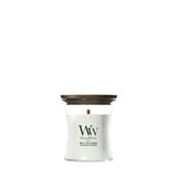 Candela WoodWick White Tea & Jasmine piccola in vaso di vetro con coperchio in legno.