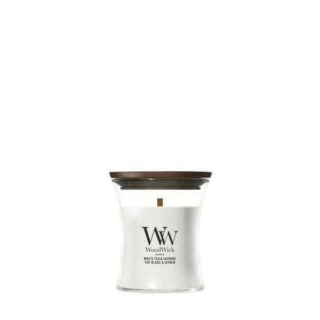 Candela WoodWick White Tea & Jasmine piccola in vaso di vetro con coperchio in legno.