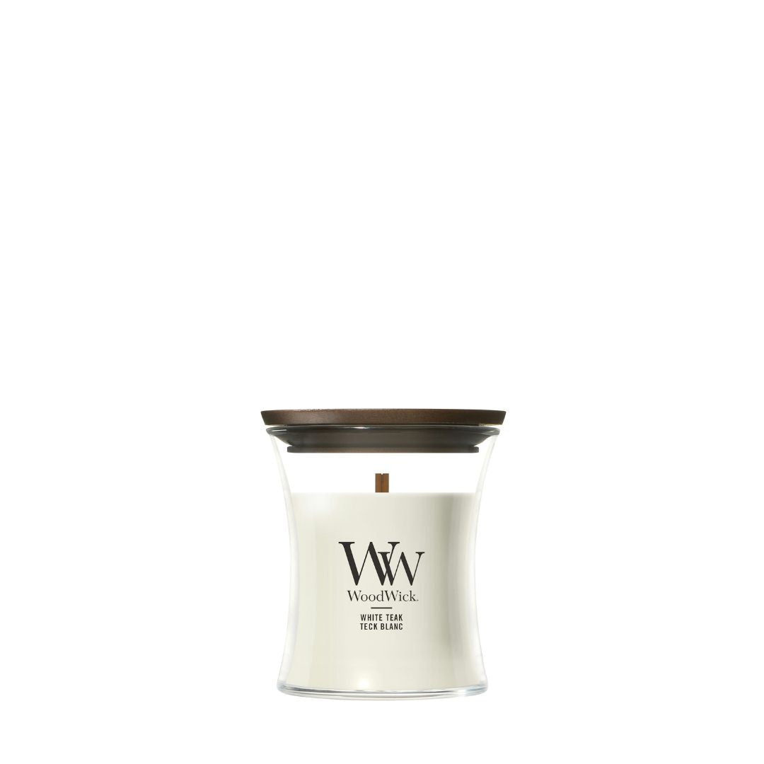 Candela WoodWick White Teak piccola in vaso di vetro con coperchio in legno.