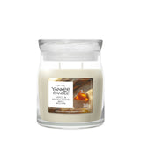 Candela Yankee Candle Amber & Sandalwood media in giara di vetro.