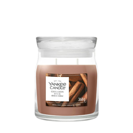 Candela Yankee Candle Cinnamon Stick media in giara di vetro con etichetta frontale.